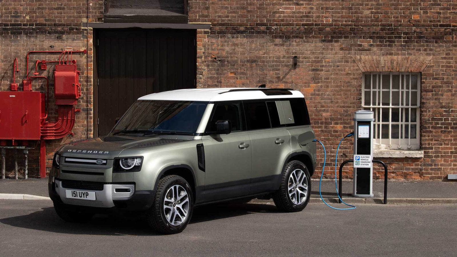Green SUV parked beside a charging point