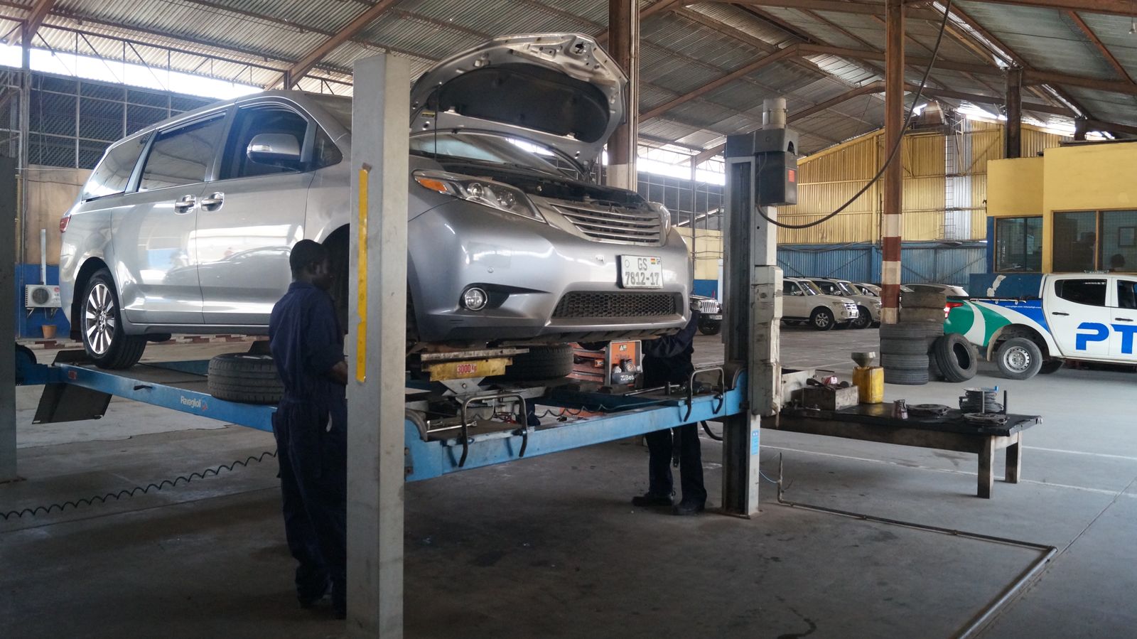 PTL technicians servicing a minivan on a lift in the PTL workshop