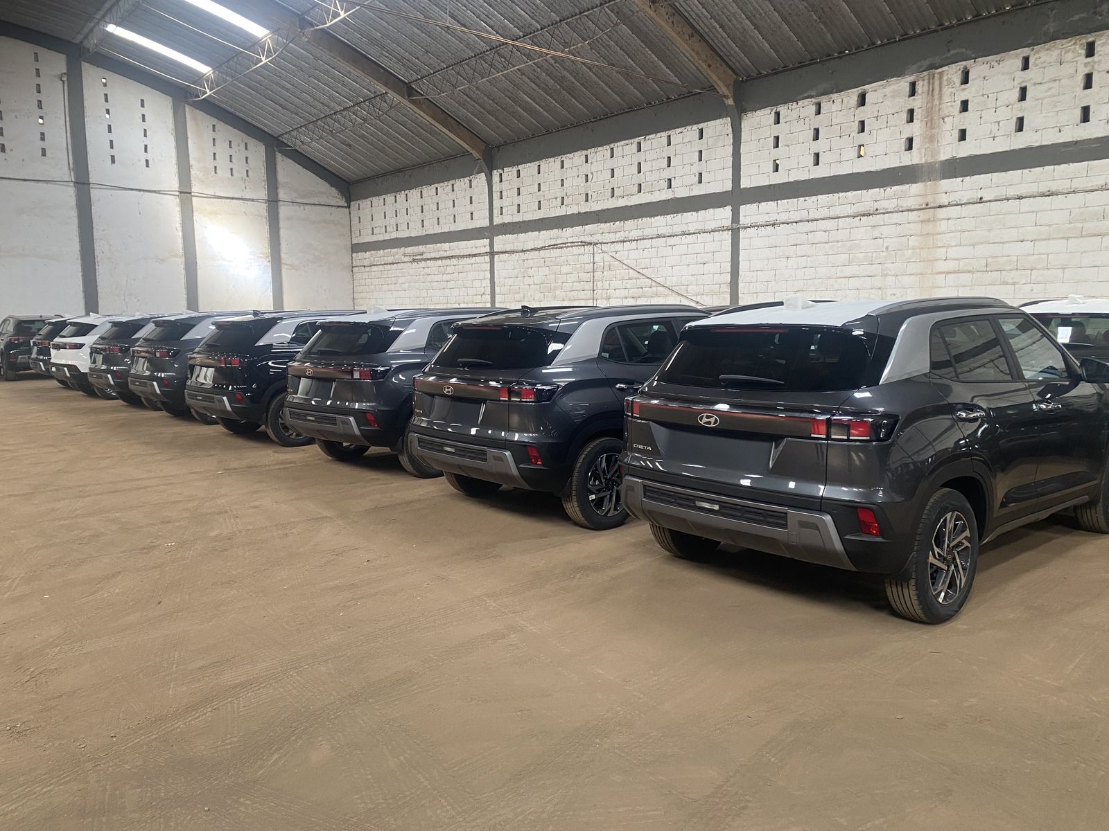 A row of new PTL SUVs parked inside a fleet warehouse